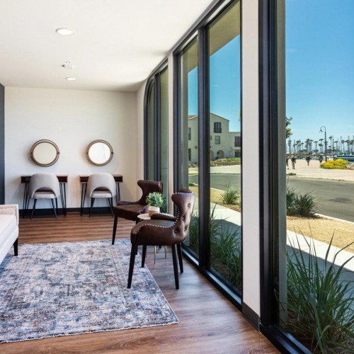 Exclusive access to resident-only features clubroom sitting area with floor-to-ceiling windows and harbor views