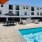 a pool beside umbrella shaded lounge chairs